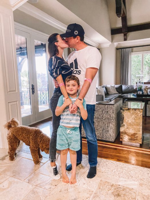 The family with their dog and their child kissing